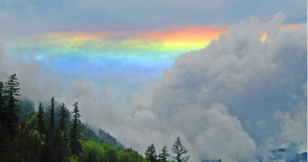 A rainbow sneaks its way through the clouds. 