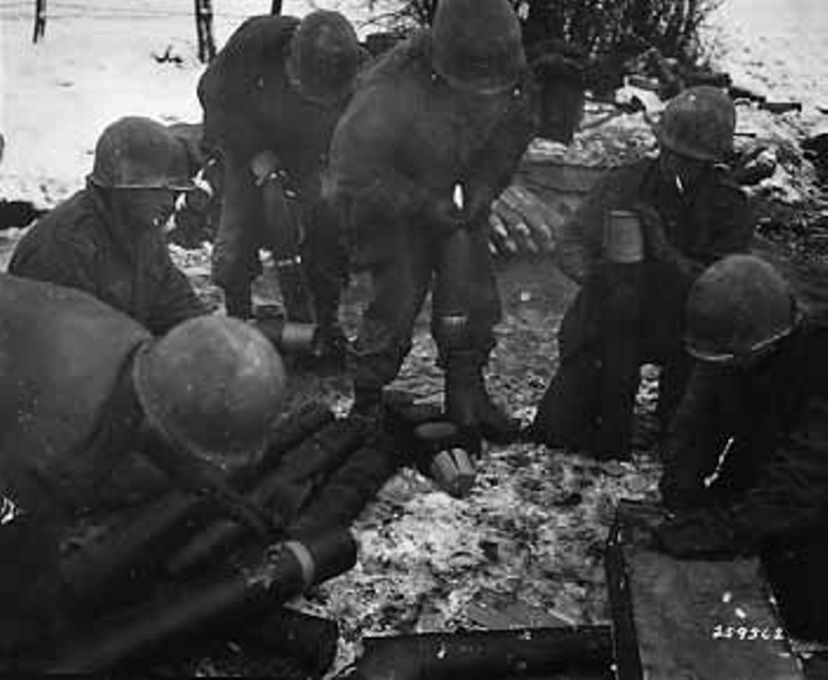 Crew in the 591st FAB preparing the shells for firing. Gotta love the GI with the cigarette next to all that powder.