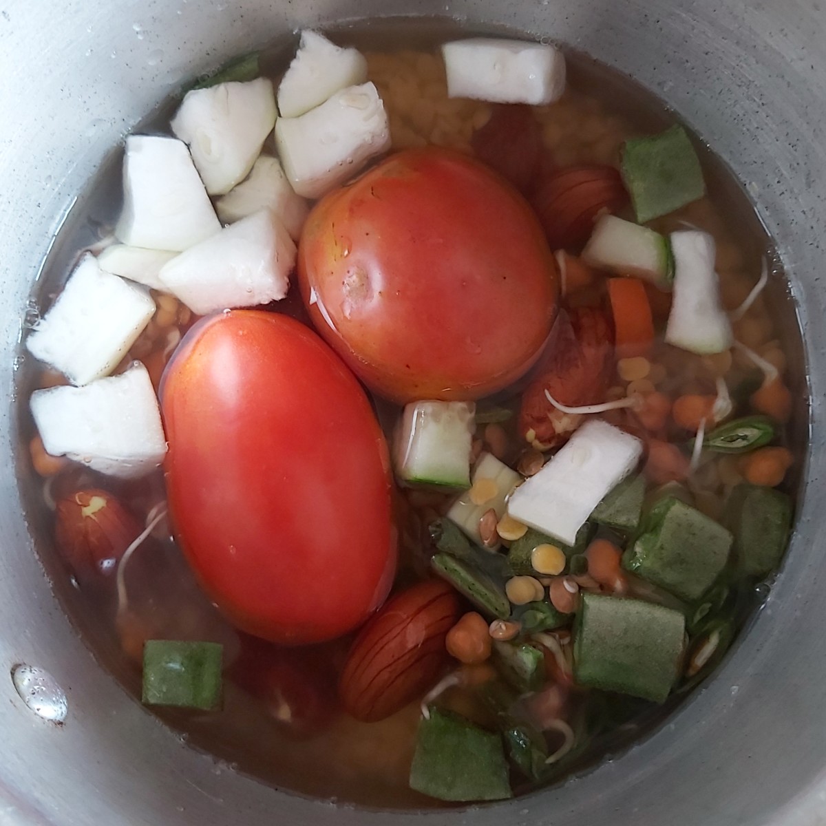 Also add 1–2 whole ripe tomatoes. Close the lid of cooker and take 3–4 whistles.