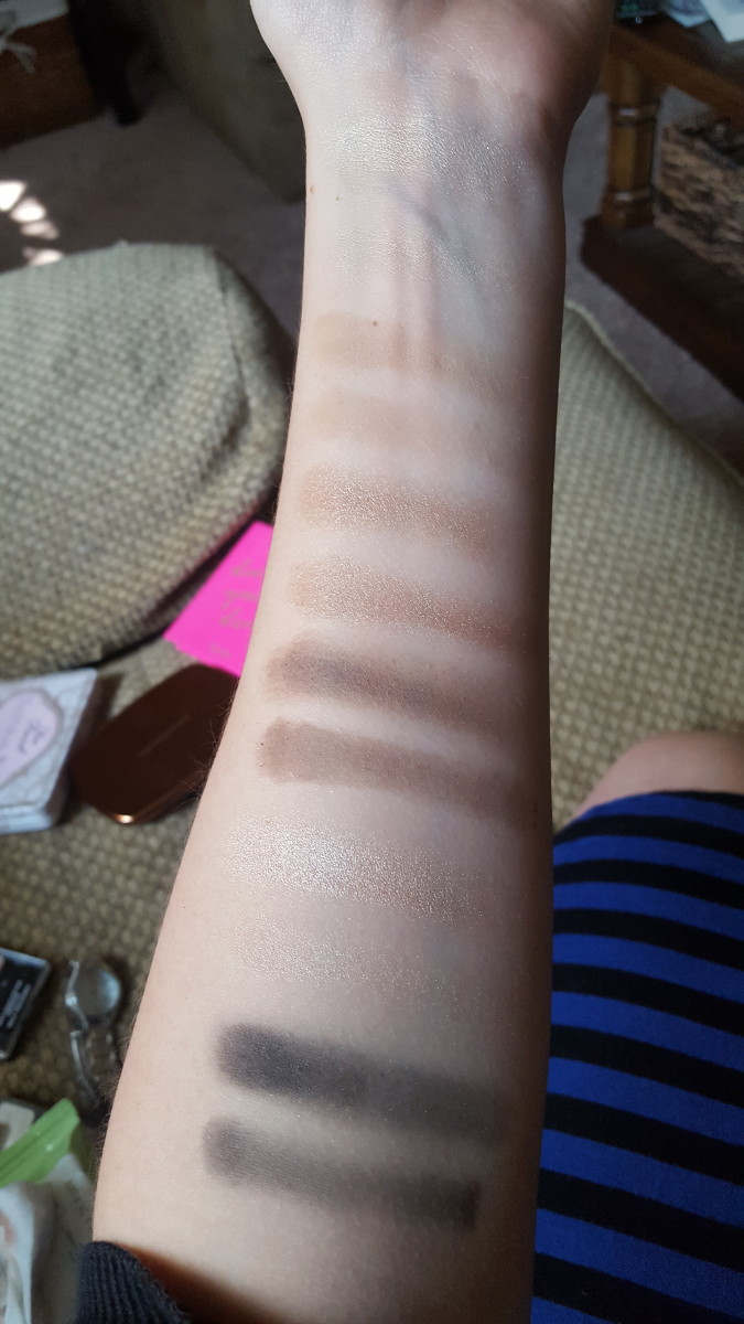 Here are the swatches from Must Have Naturals, with finger swatches at the top and brush swatches below each one. From top to bottom are the beige highlight, the transition shade, the shimmery brown, the dark brown, the pink highlight, and the black.
