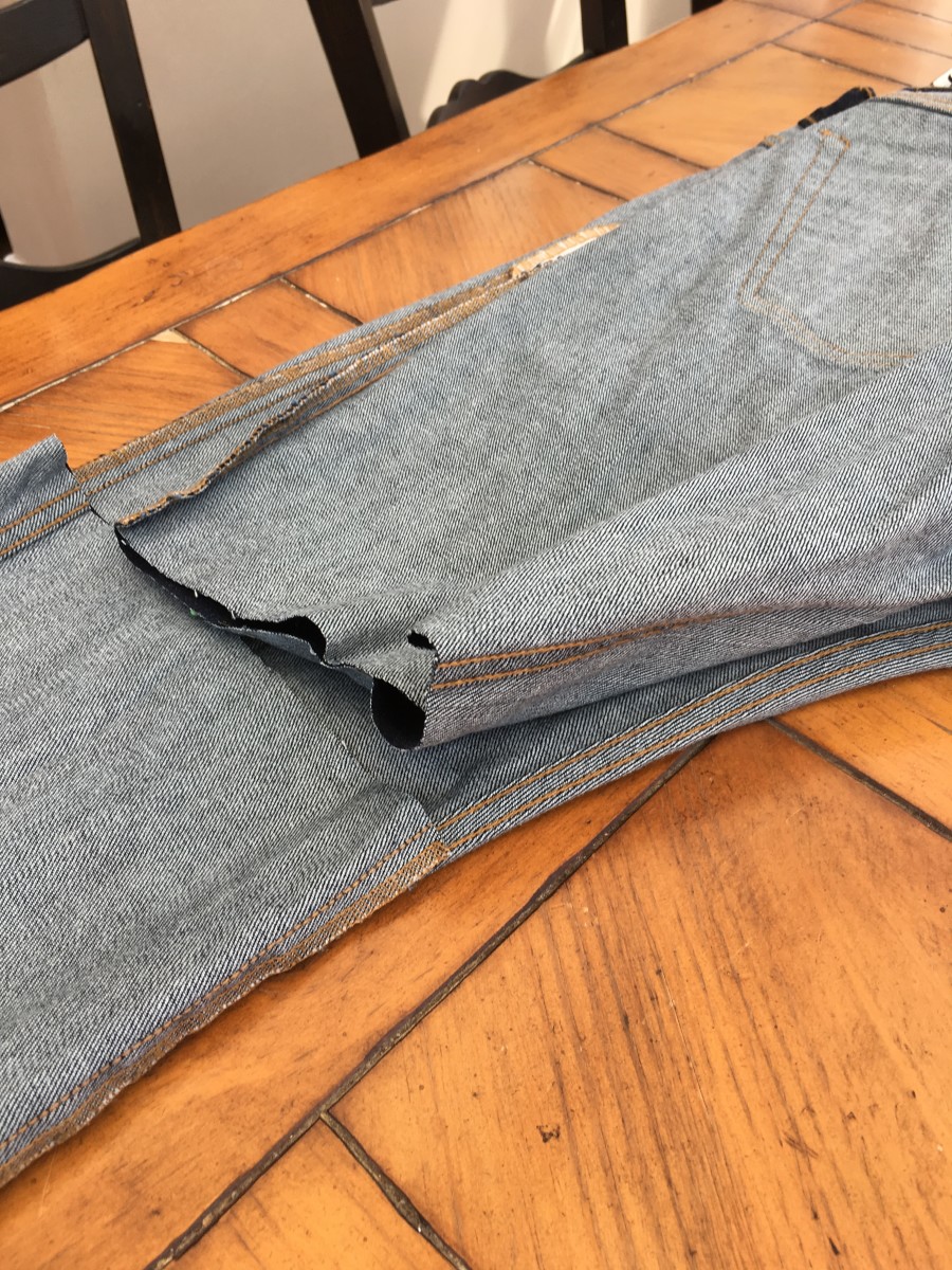 Fold the jeans in half to make sure the length and angle of the cut are the same on both legs.