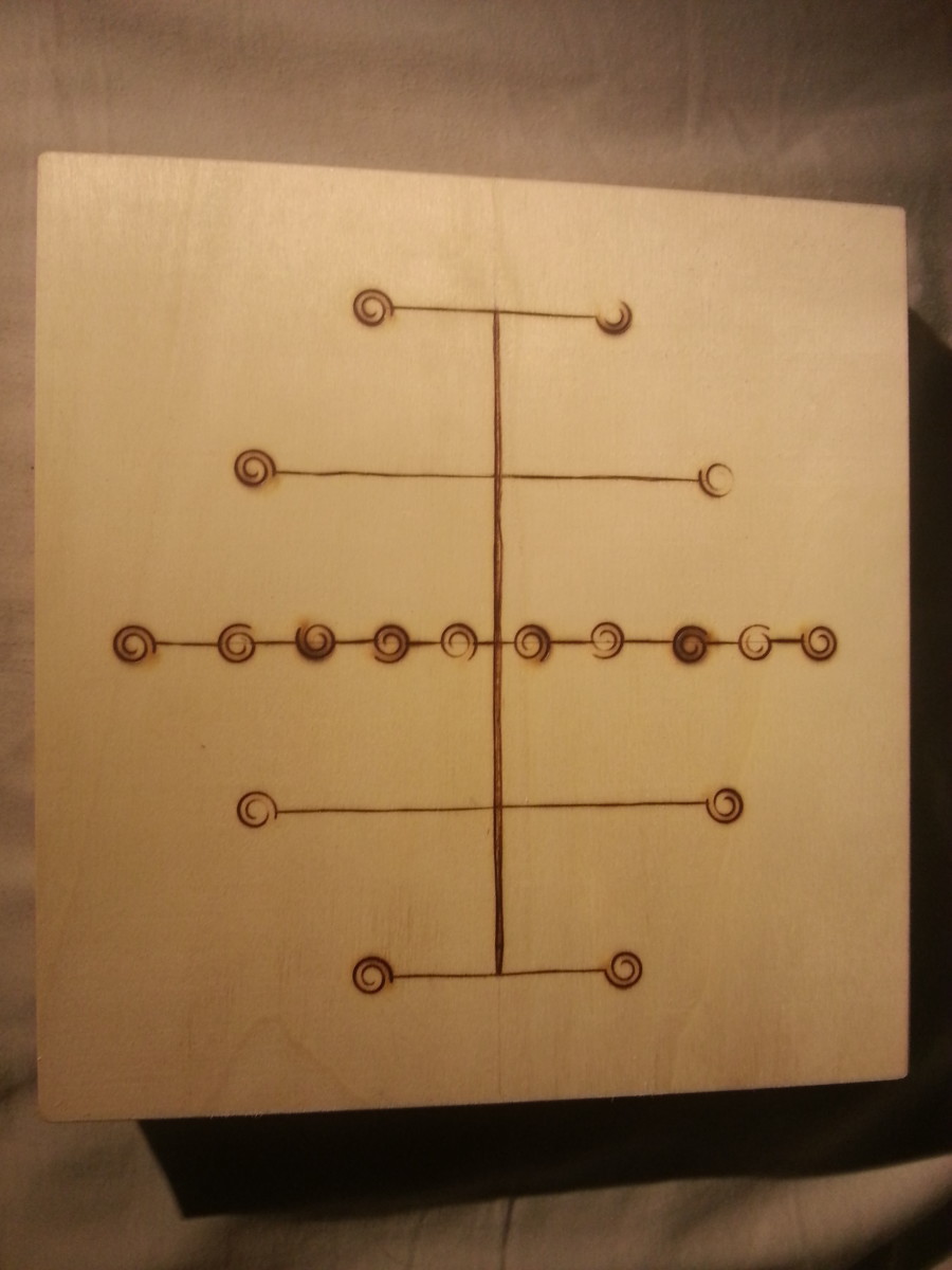 This is an example of a five lines board that I created. The decoration is made using wood burning techniques.