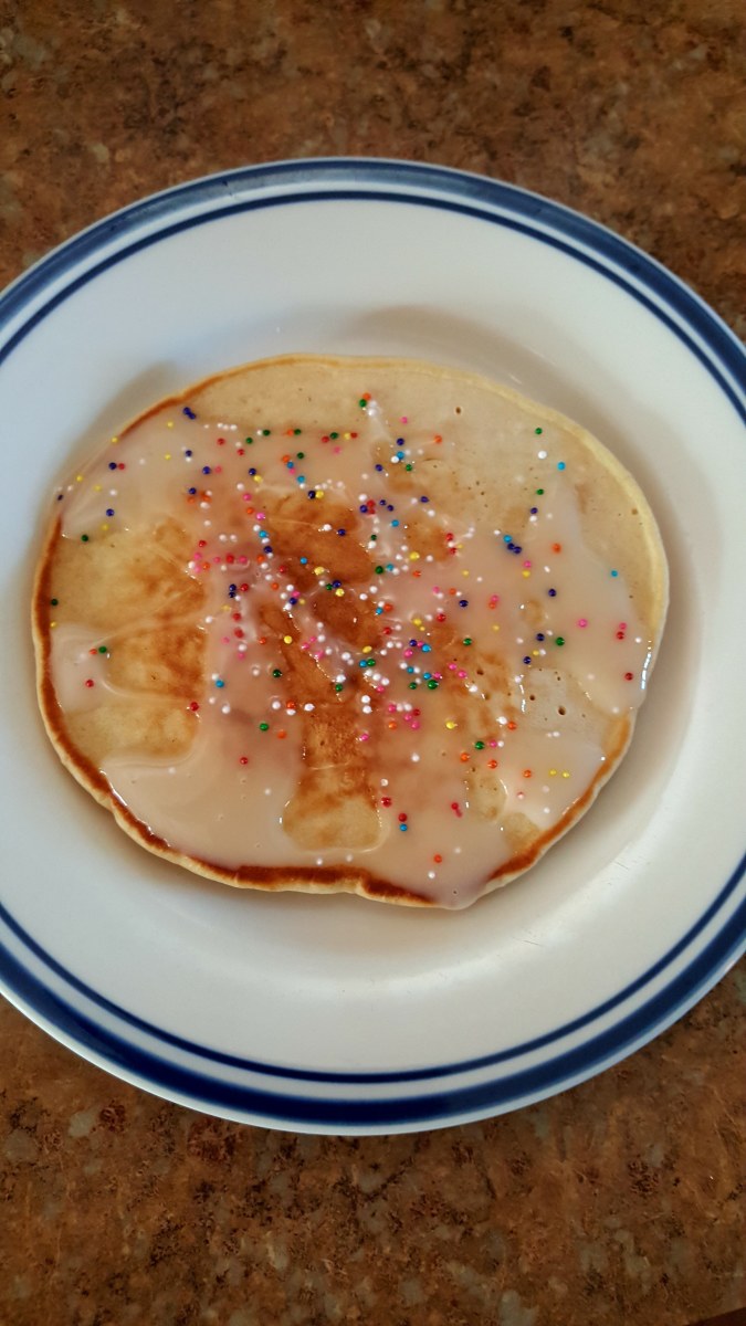 Delicious cake batter pancake with vanilla glaze and sprinkles.