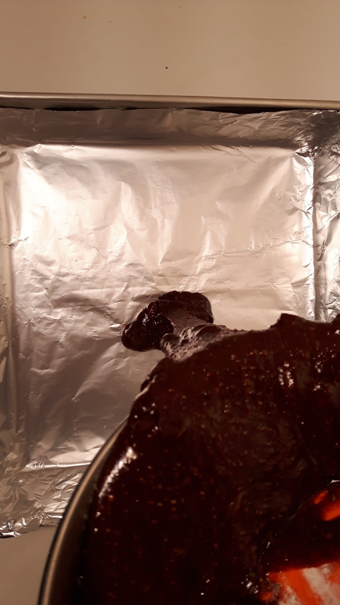 Pouring the brownie batter into the foil-lined pan