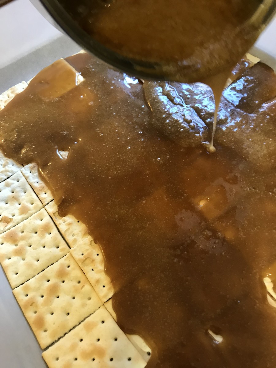 Pour Toffee Over Crackers: Slowly pour toffee over the top of the saltine crackers. If you move slowly, you won't knock all your crackers out of whack. The toffee will self-level pretty much, so don't stress.