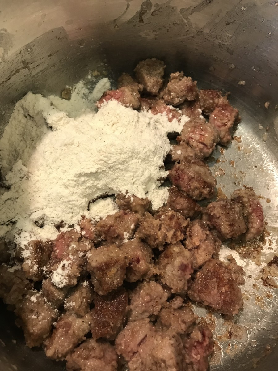 Once the beef is browned, toss in the remaining seasoned flour. You'll be seasoning the beef stew in stages, ensuring it is deep in flavor and really rich and 'beefy' tasting. Stir in the flour well.