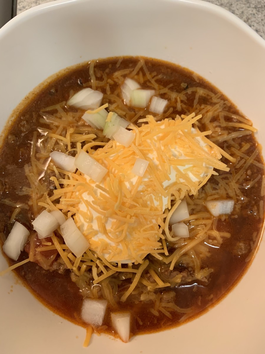 A simple keto beanless chili topped with sour cream, cheese, and onions.