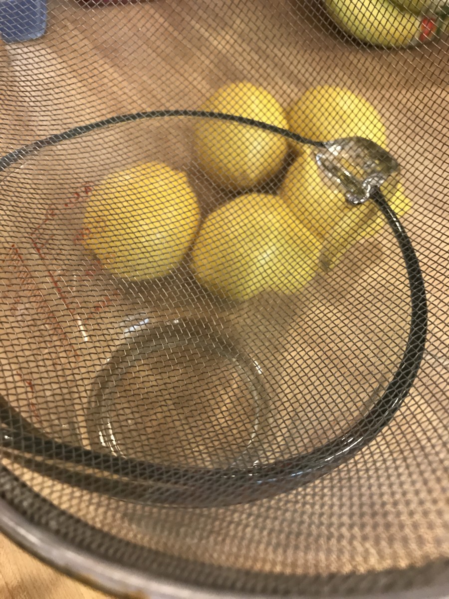 It's important to strain the finished lemon curd while it's hot. Place a large mesh strainer over a large bowl.