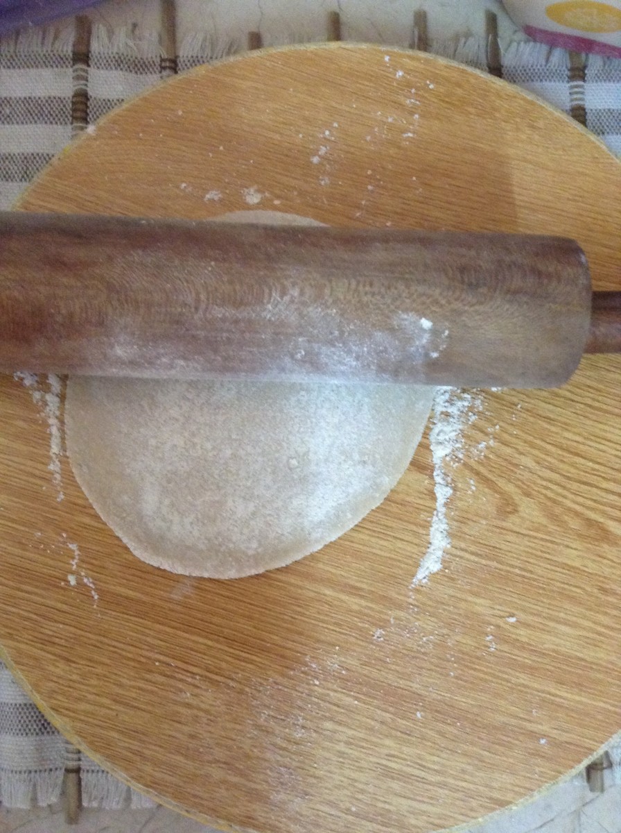 Flatten the ball of dough using a rolling pin. You are to flatten it in such a way that its circular shape will not distort ...