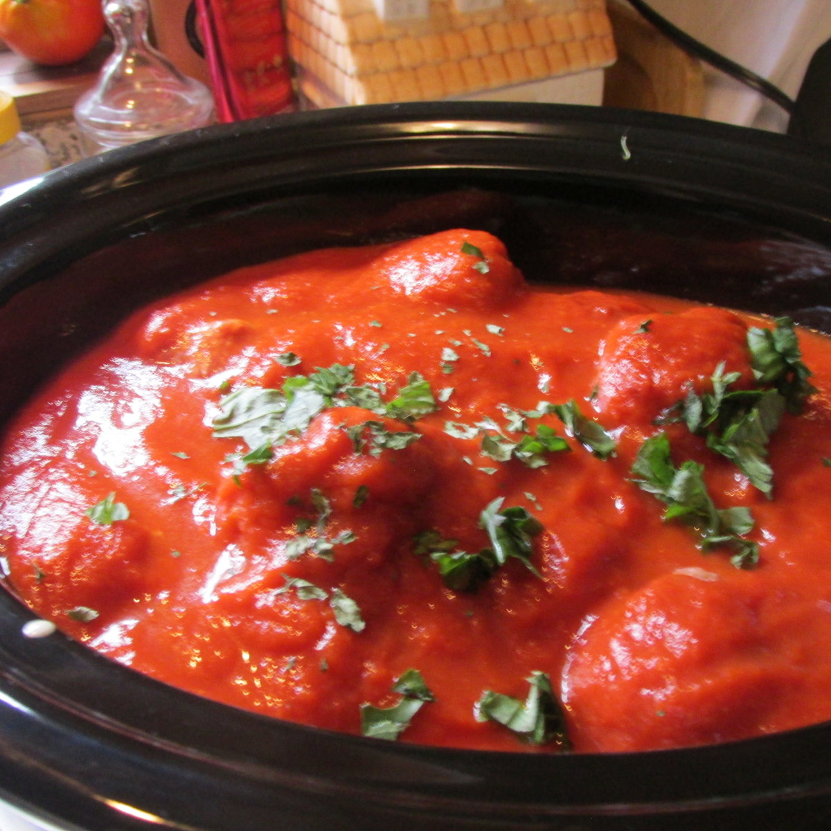 Add a second jar of tomato sauce on top of the meatballs. Add fresh chopped basil.