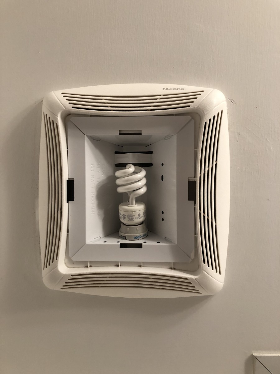 Pay attention to the manufacturer's assembly instructions. Tightening a nut on this unit's metal light bulb fixture forces the plastic fan louver tight against the ceiling and  the light cover snaps into the rectangular slots next to the louver.