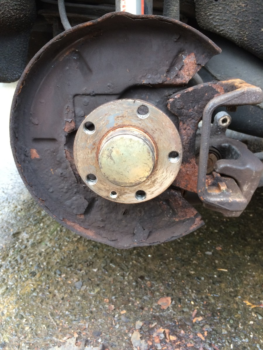 The corroded back plate covered in brake dust became visible when the disk was removed.