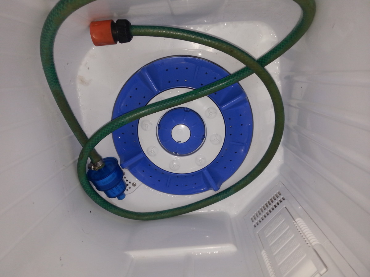 Storing the garden hose I use instead of the supplied white hose. Note one end is attached to the blue insert for the washing machine. The other end has a standard fitting for an external tap. I use the hose indoors and outdoors. (See below.)