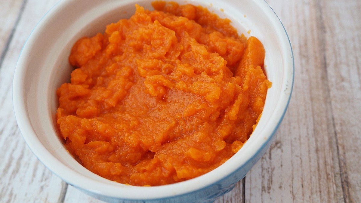 Cook and mash carrots before offering them to your dog.
