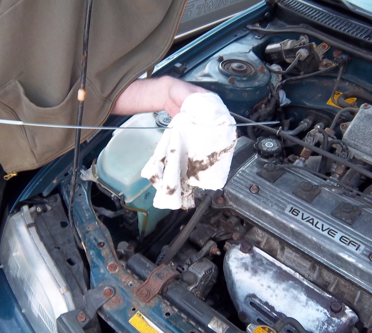 Use a rag to wipe the oil off. Place the dipstick all the way back in. Then pull out again to get an accurate reading.