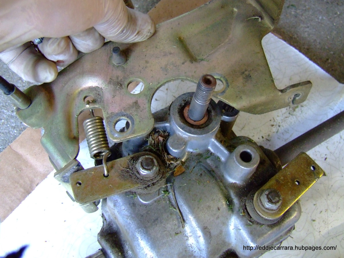 Remove the metal bracket from the transmission on the Honda Harmony 215