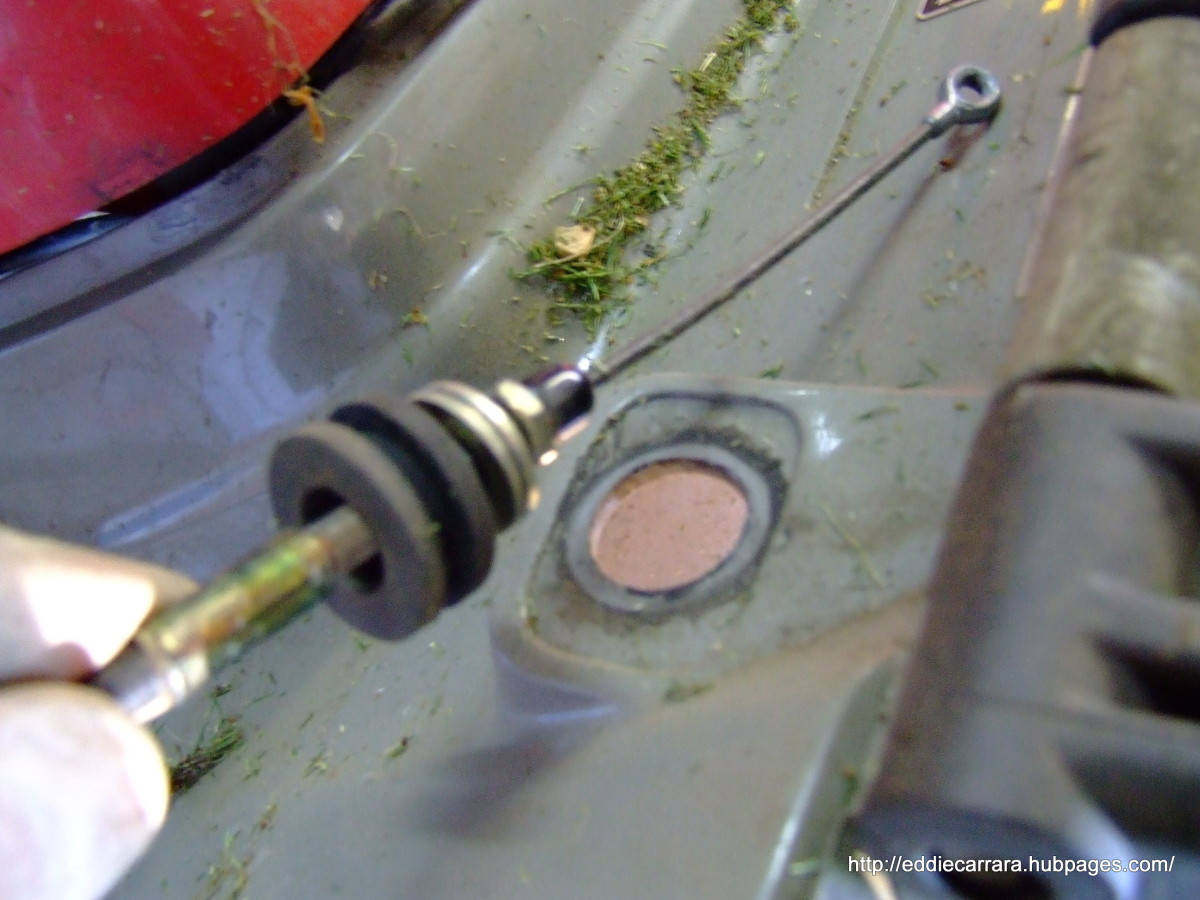 Remove the rubber grommet from the mower deck on the Honda Harmony 215 and keep the cable assembly together.