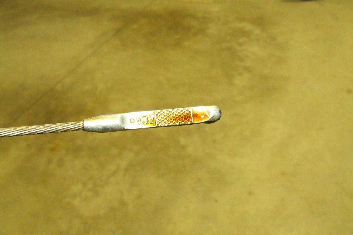 Oil dipstick. Notice the brownish color of the motor oil or engine oil.
