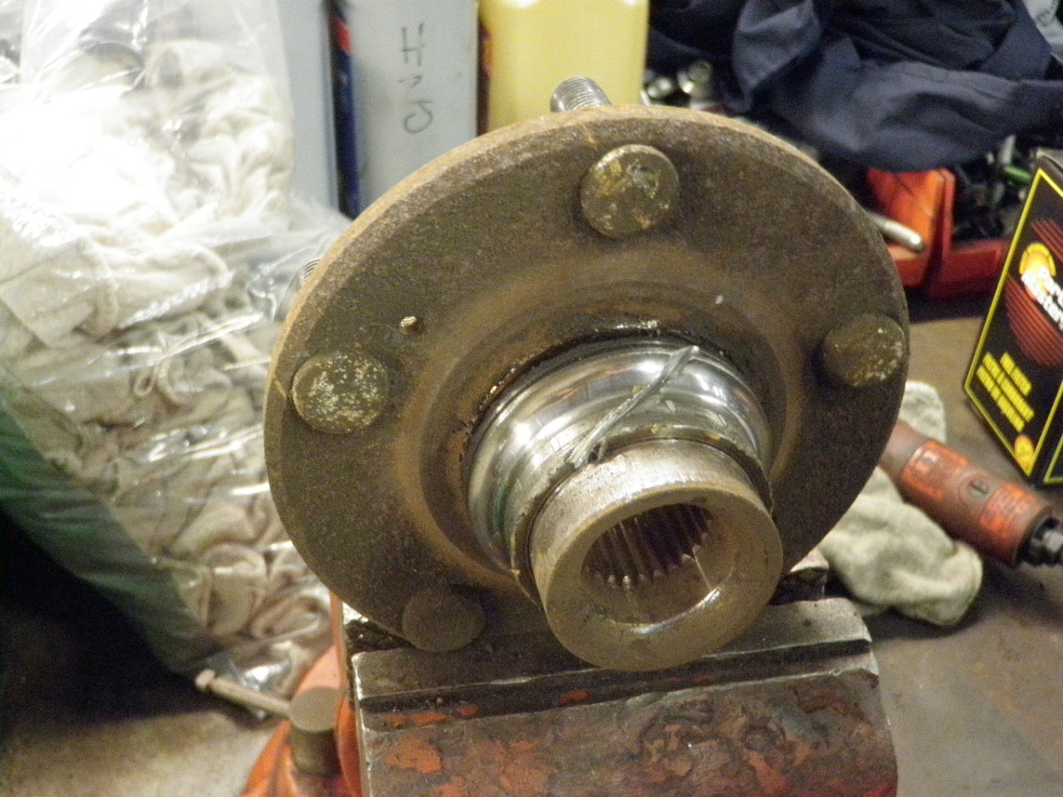 Using a high speed cut off wheel, make a slice in the center race still pressed on the hub.
