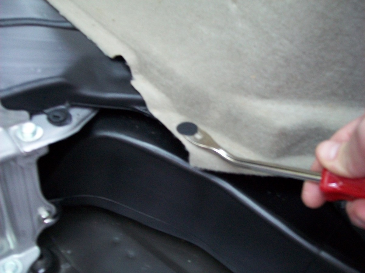 Remove upholstery push pin and pull out right-rear interior panel.