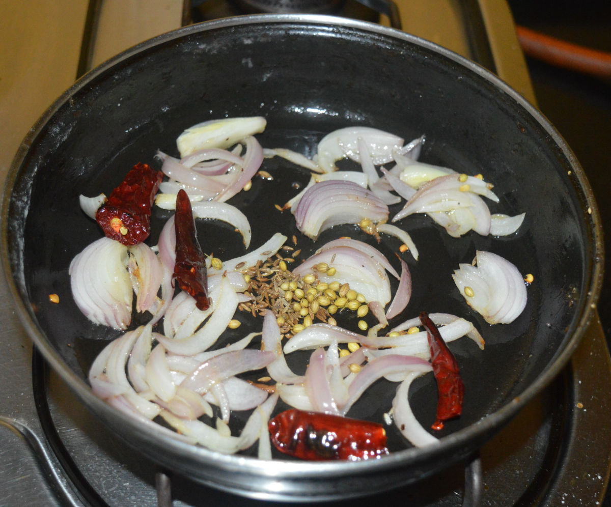 Step one: Saute cumin seeds, coriander seeds, and red chilies in some oil. Add chopped onions. Saute the mixture until the onions become pinkish.