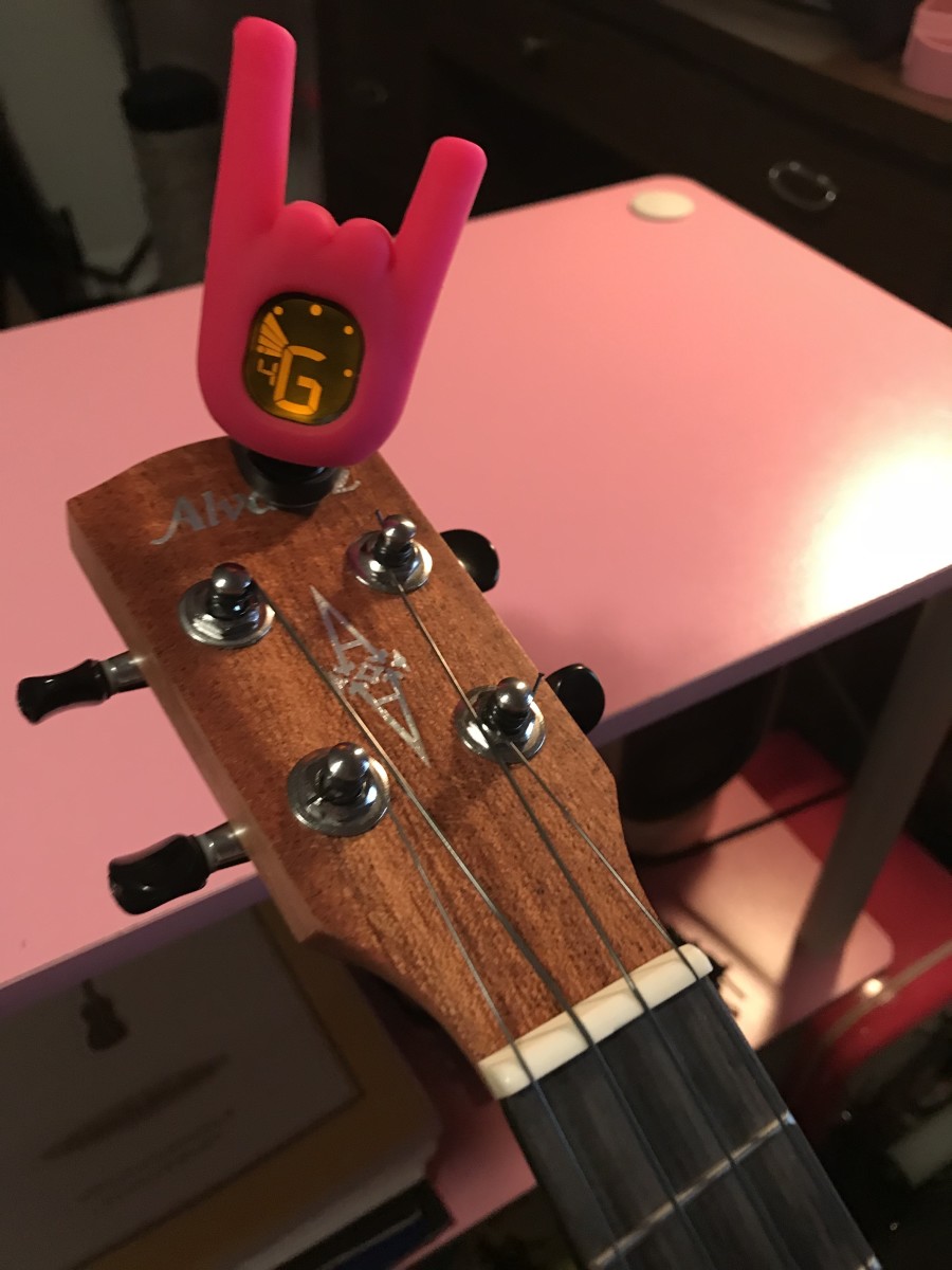 Tuning a ukulele with a clip-on electronic tuner.