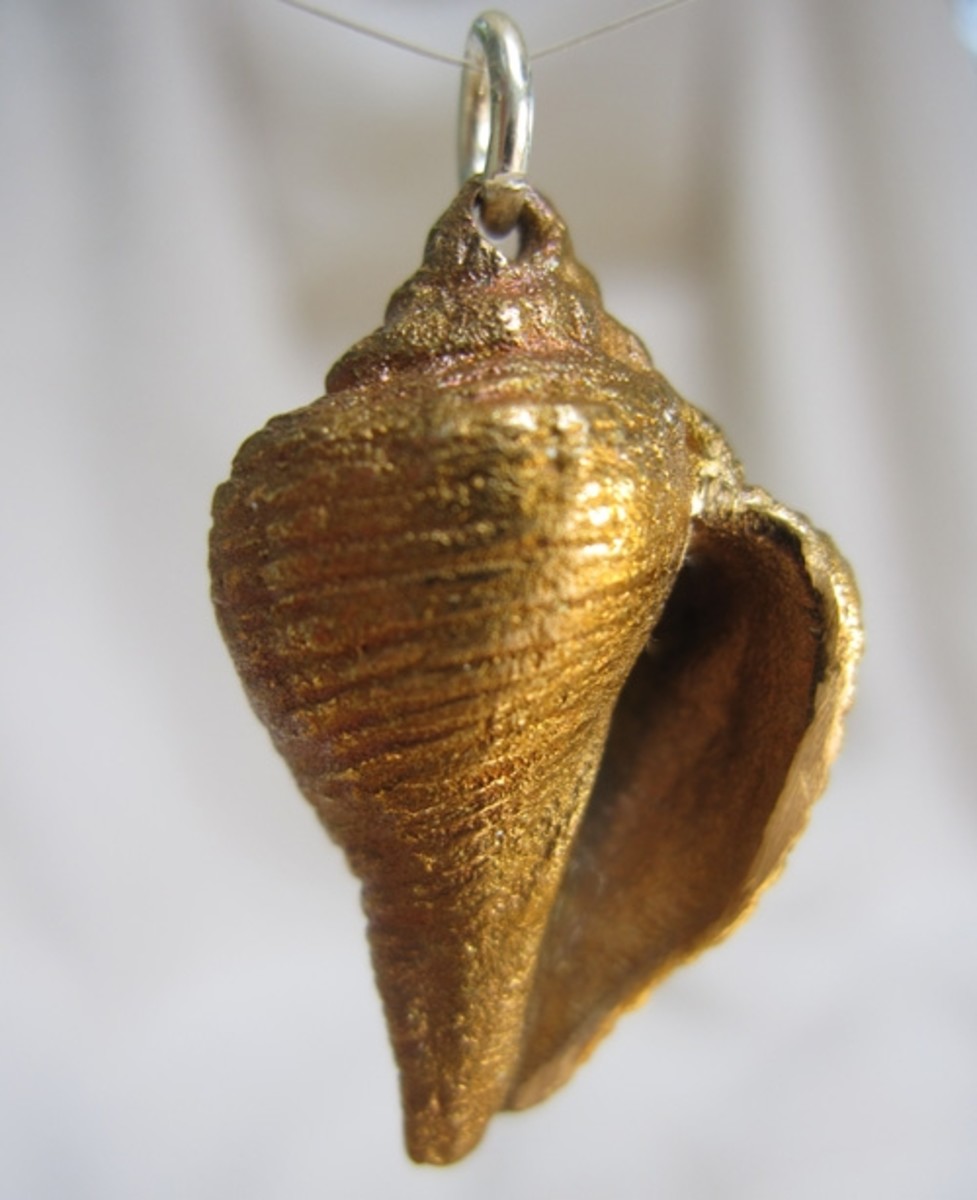 Bronze shell charm (approximately 1" long) molded from a seashell picked up on the beach, given a light iridescent torch patina after kiln firing