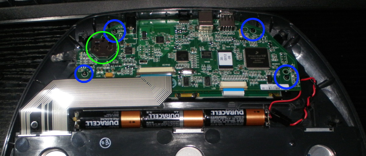 Remove another four T6 screws circled in blue, from the motherboard.  The battery holder is circled in green.