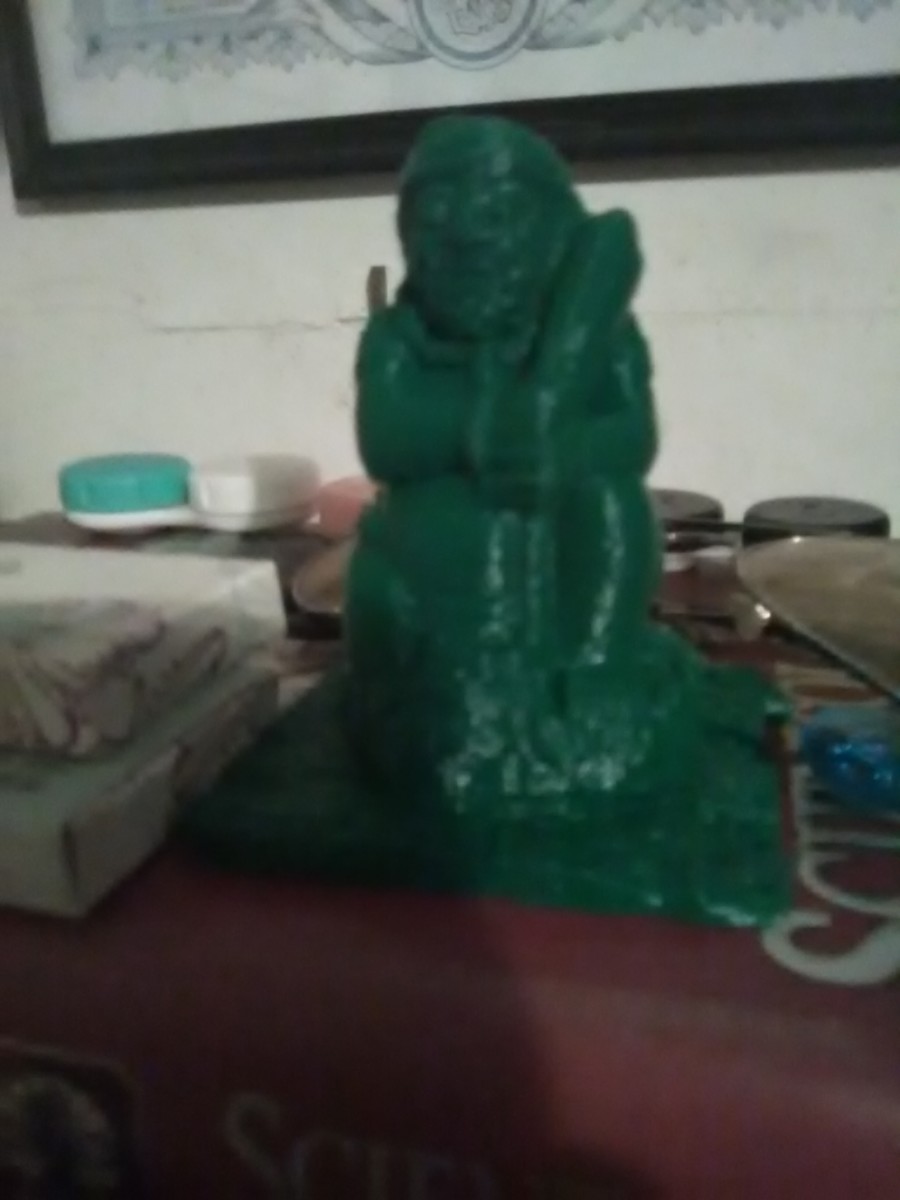The 3D-printed object is the green plastic statue