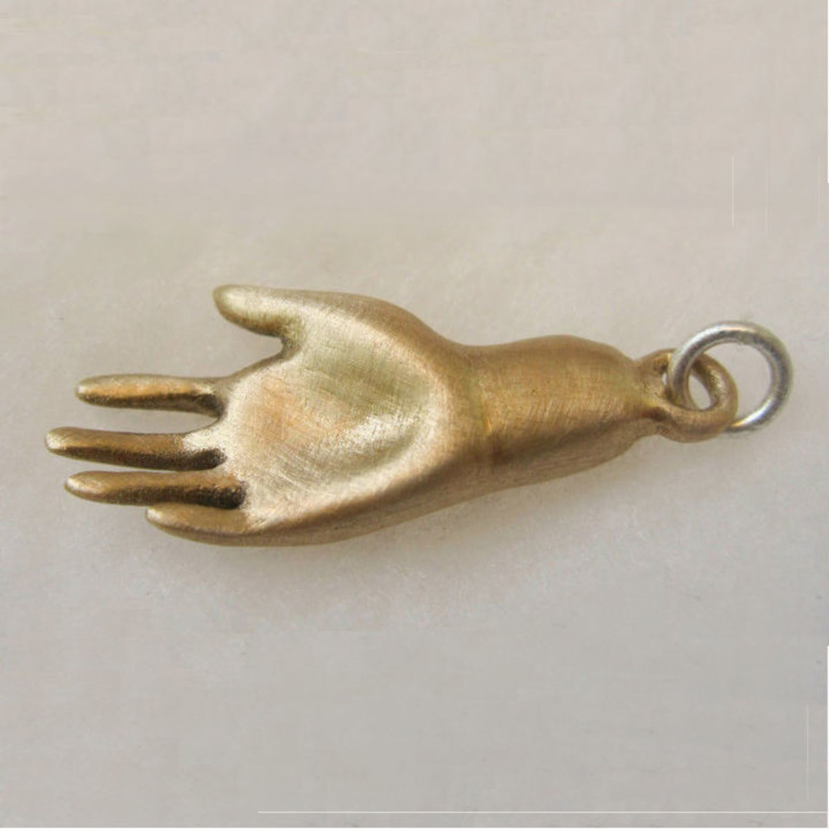 Bronze clay hand charm with a scratch-brushed finish to add surface texture interest. Polishing it to a high shine would have given it a very different look.