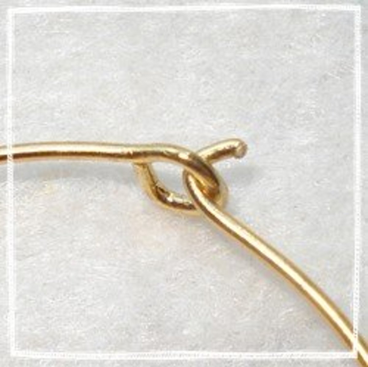 With the needle nose pliers, make a loop with one end of the wire. Bend the other side of the wire up to make a tab for your wine glass rings.