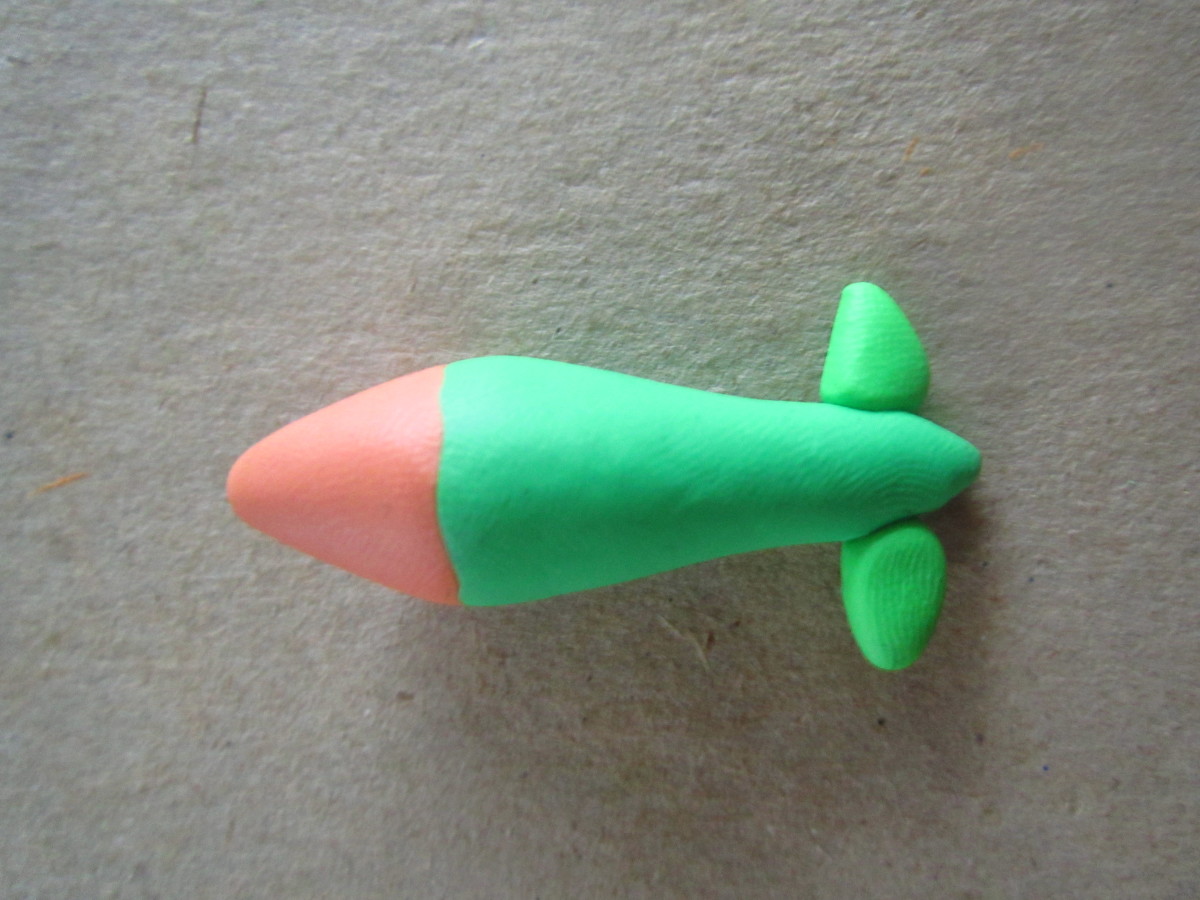 Next, I took a ball of the clay for the body, flattened it on one side, and pressed it onto the tail—blending the edges and creating a cone shape.