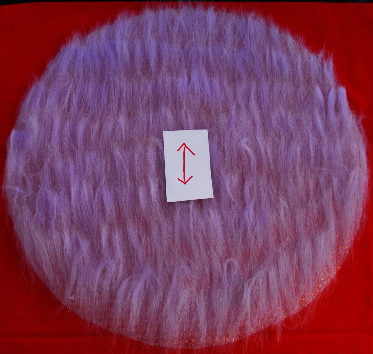 Arrow shows the direction in which the small pieces of roving should be placed. Try to space them  evenly  without leaving any gaps.  Gaps mean thin spots in your finished pod.