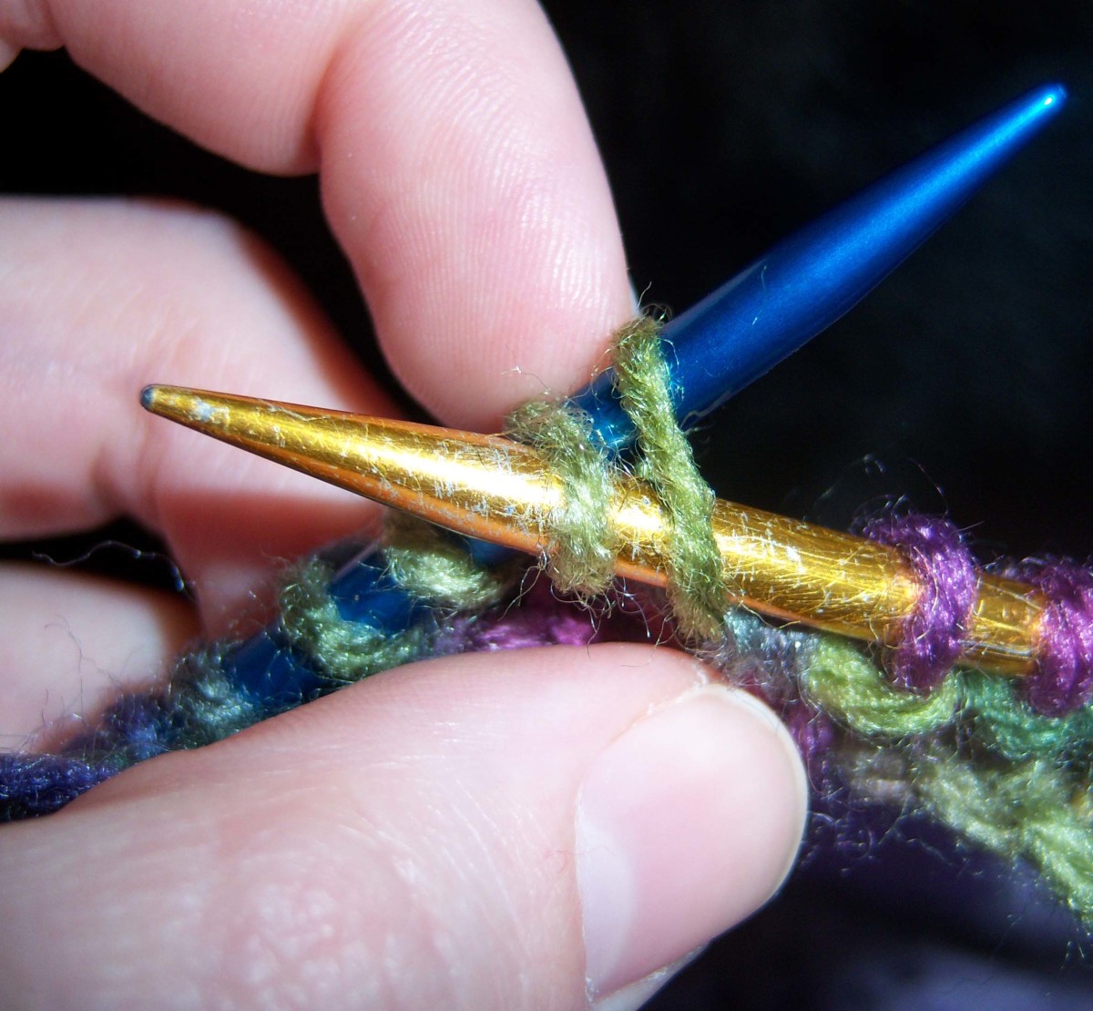 When purling two together, insert the gold needle through two stitches instead of one.