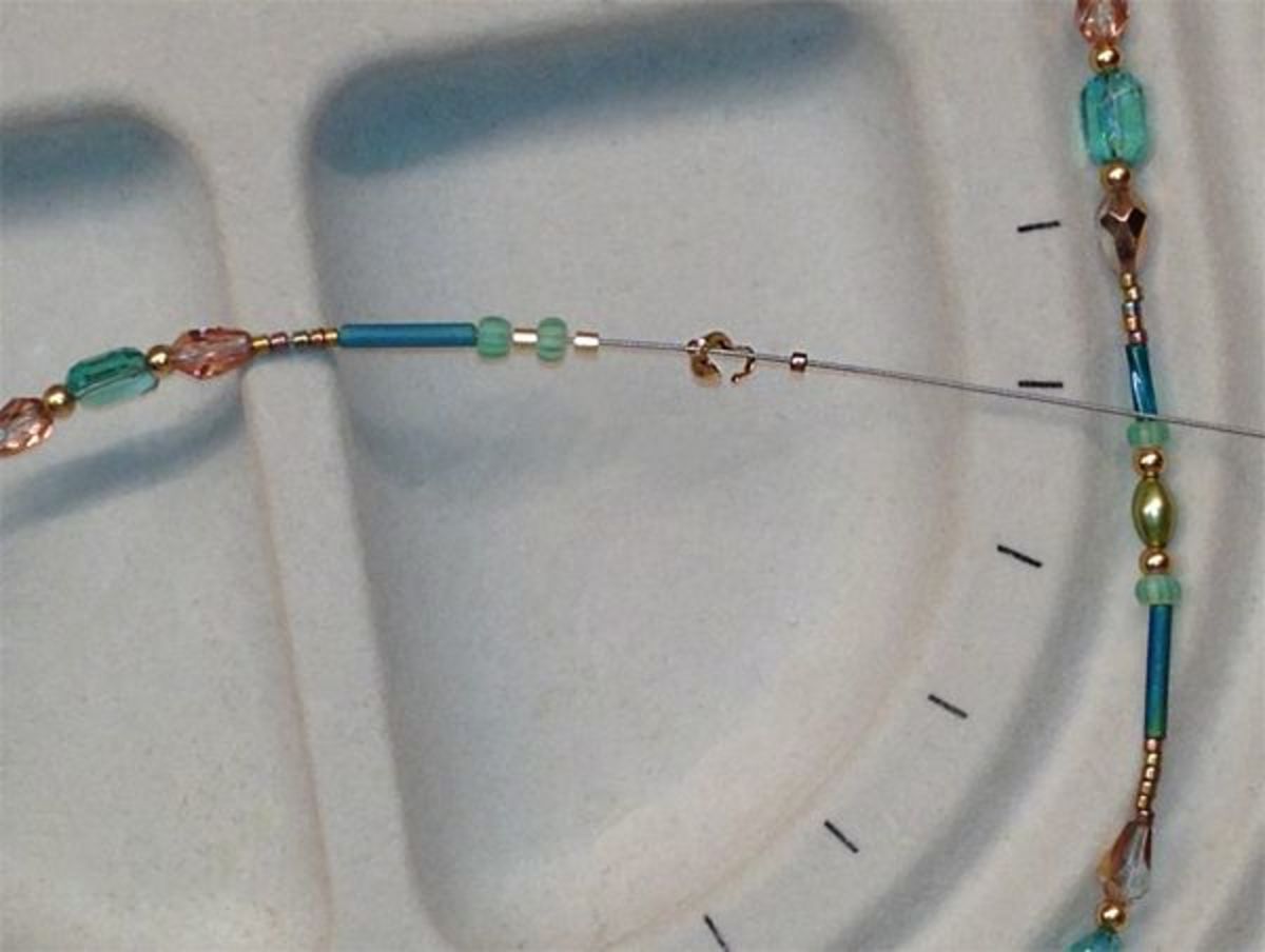 Threading the crimp tubes, beads and clamshell bead tip on the other end of the wire.