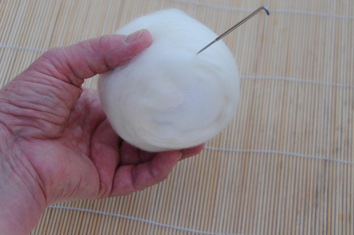 Attach white wool roving to the ball with a felting needle.