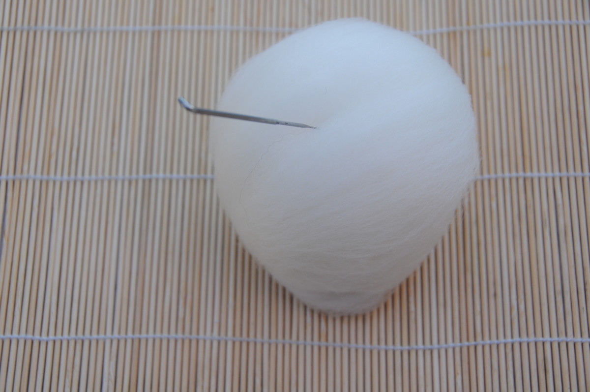 Smooth down the wool and needle felt into place, just enough to maintain the shape of the ball.