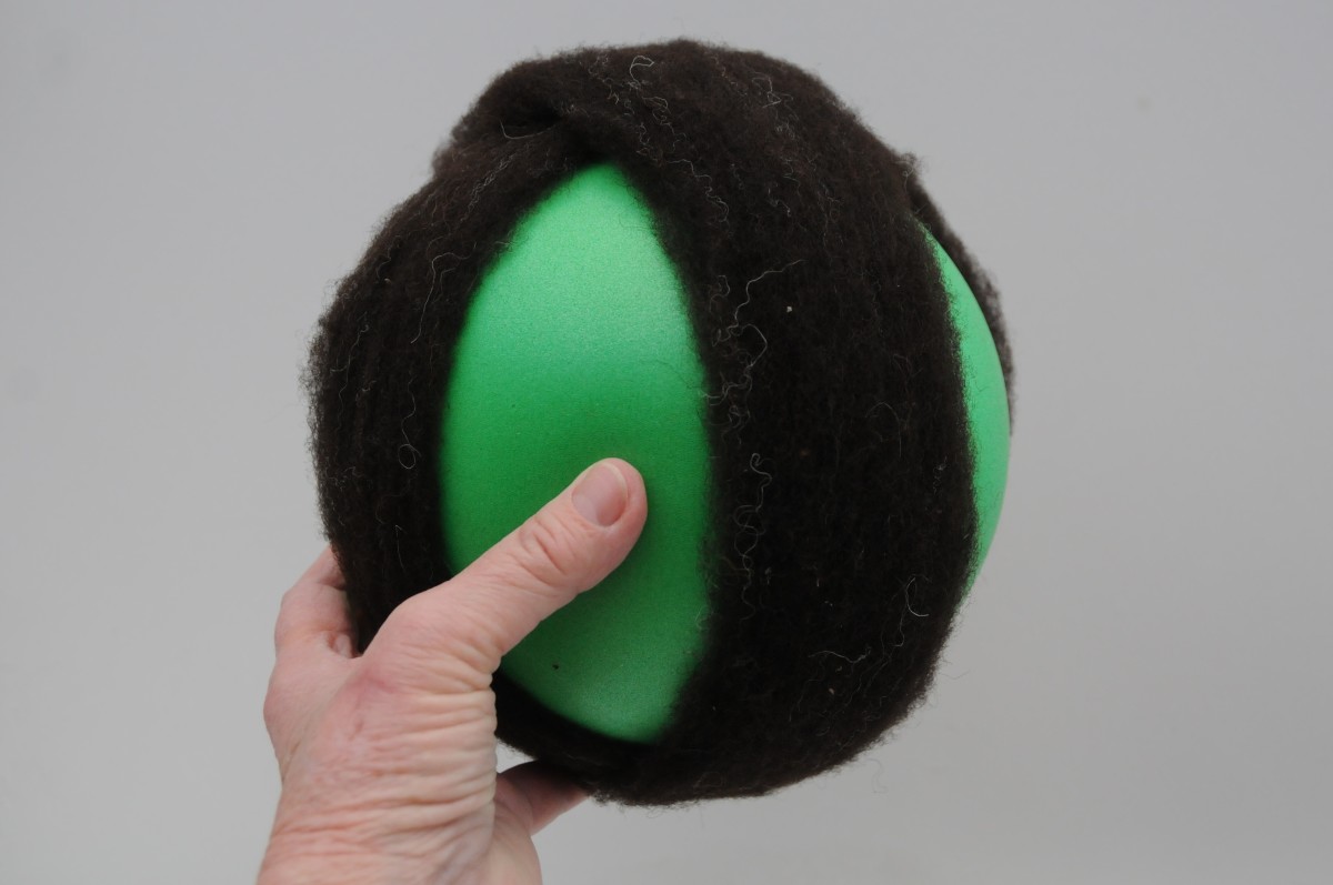 Two lengths of wool which have been placed right around the ball