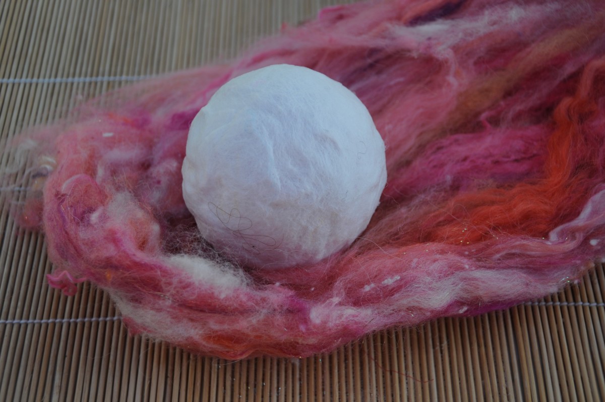 Preparing to cover the ball in a thick layer of wool fibres taken from the wool batt