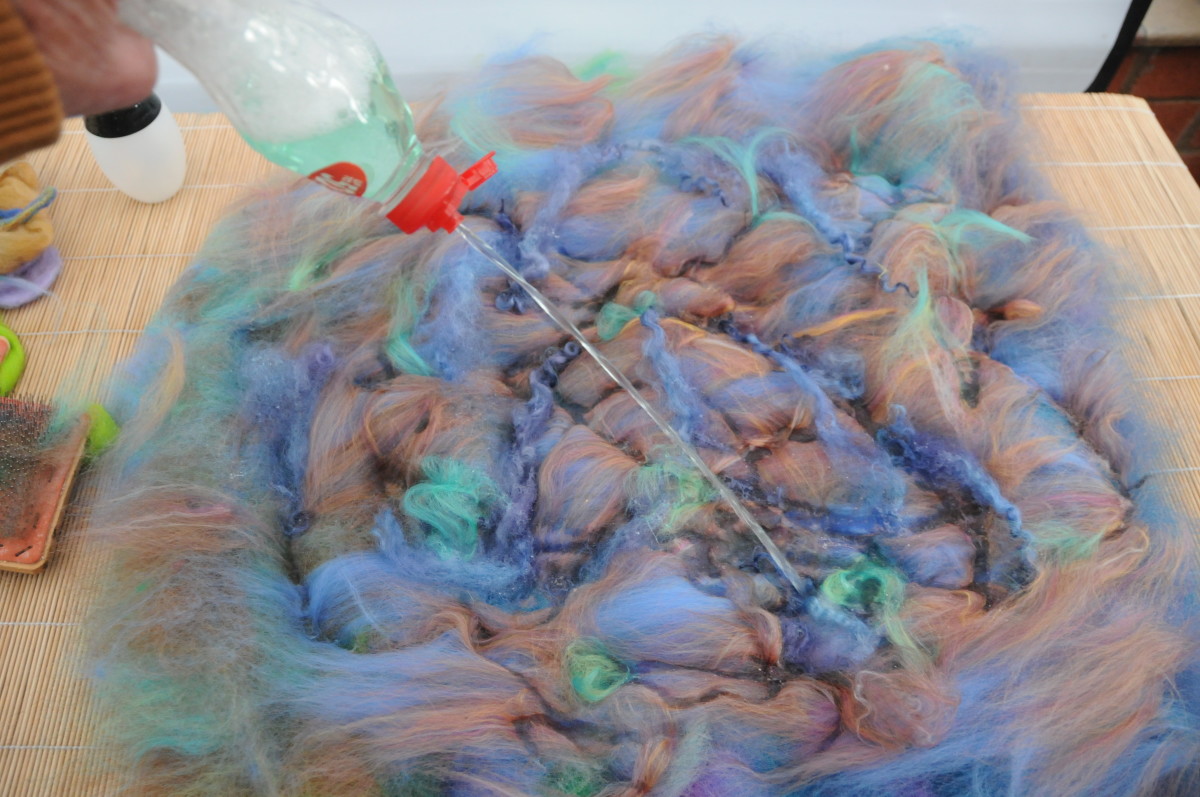 After applying the surface embellishment fibers, wet the wool.