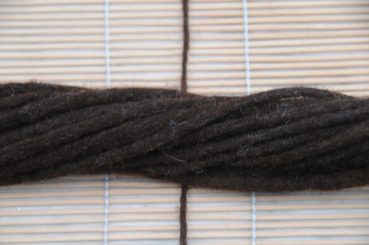 Twist and tie half of the dreads together at the middle point using a section of one Dreadlock