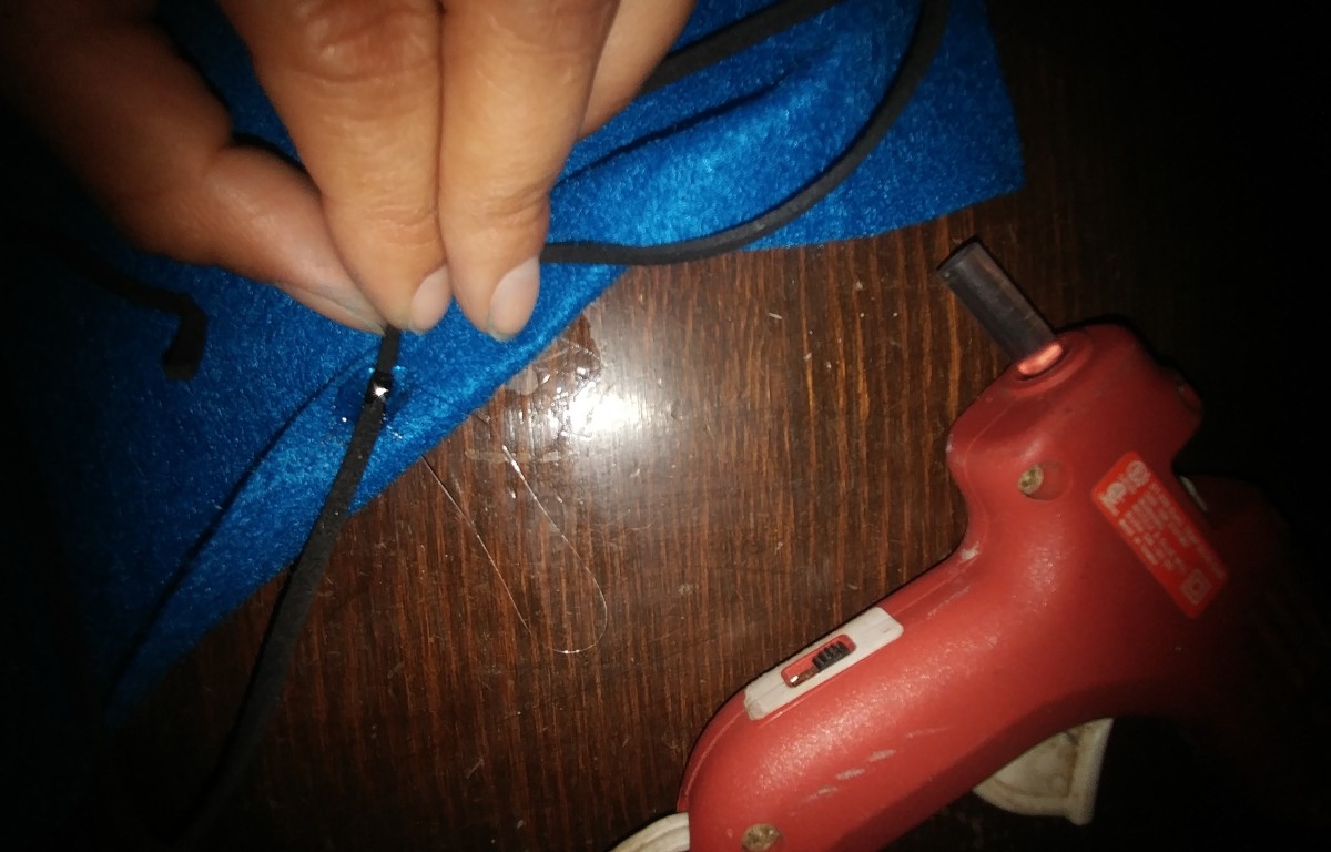 Hot glue tie cord or string on one side, on the edge of the felt.