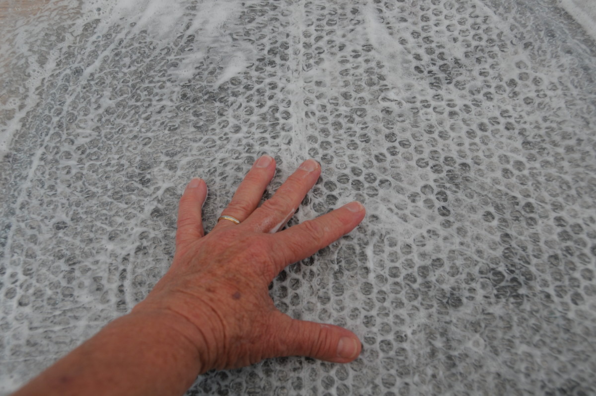 Rubbing the wet surface of the bubble wrap.
