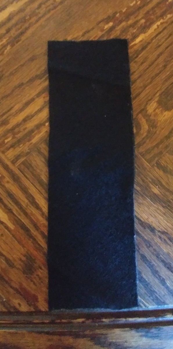 Cut black felt eight and a quarter inches by three and a quarter inches.