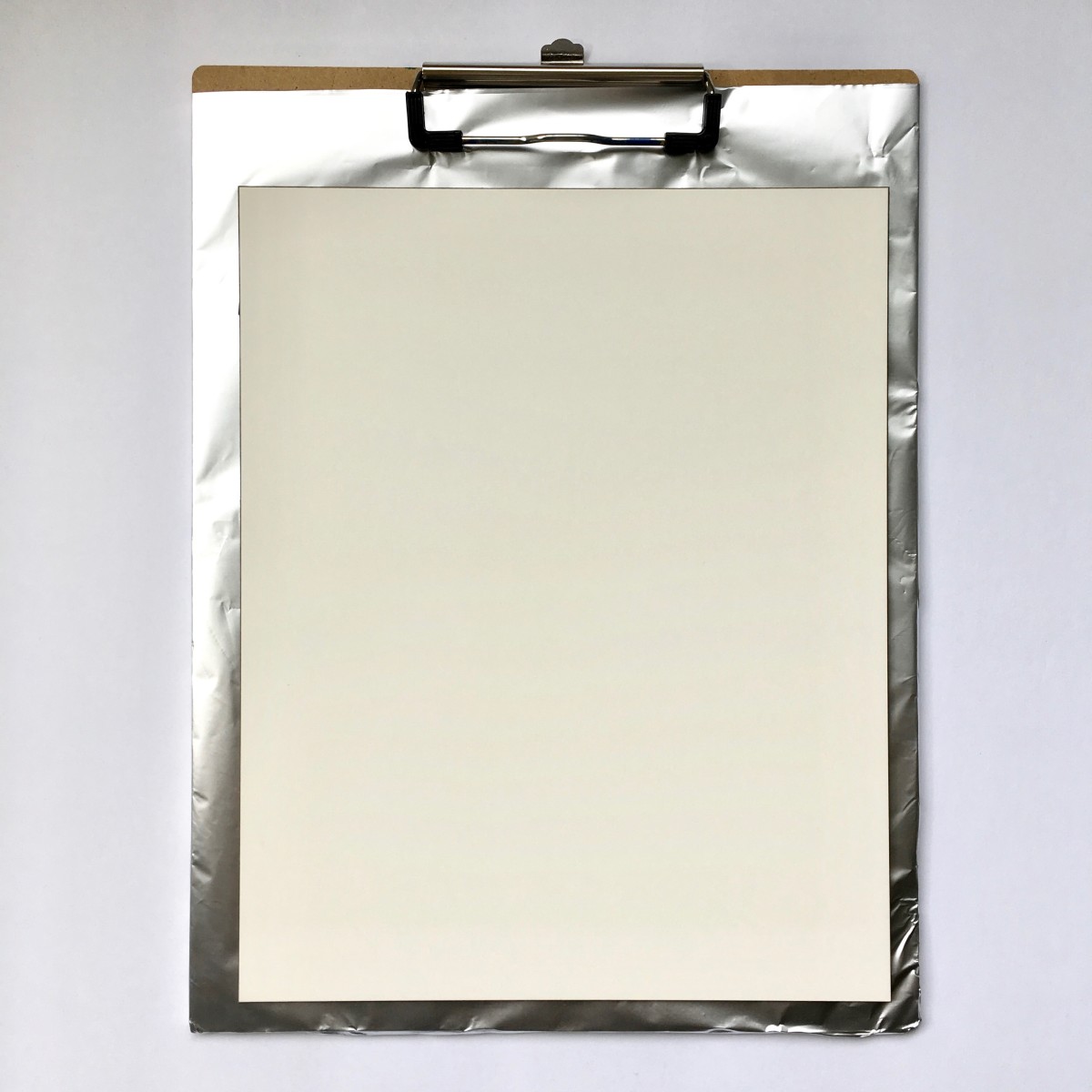 A clipboard covered with foil gives a flat, stable surface to work on.