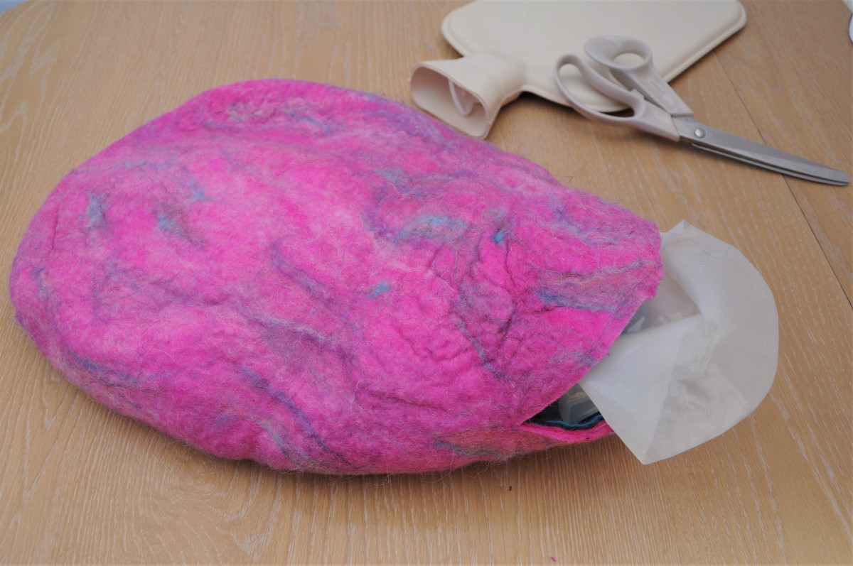Extracting the template from inside the wet felted water bottle cover.