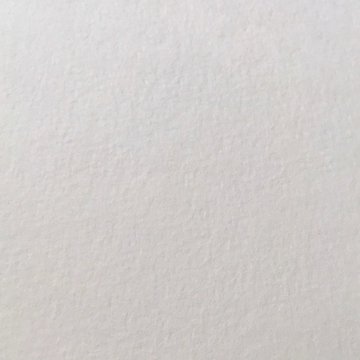 A close-up showing the texture of a sheet of cold-pressed watercolor paper