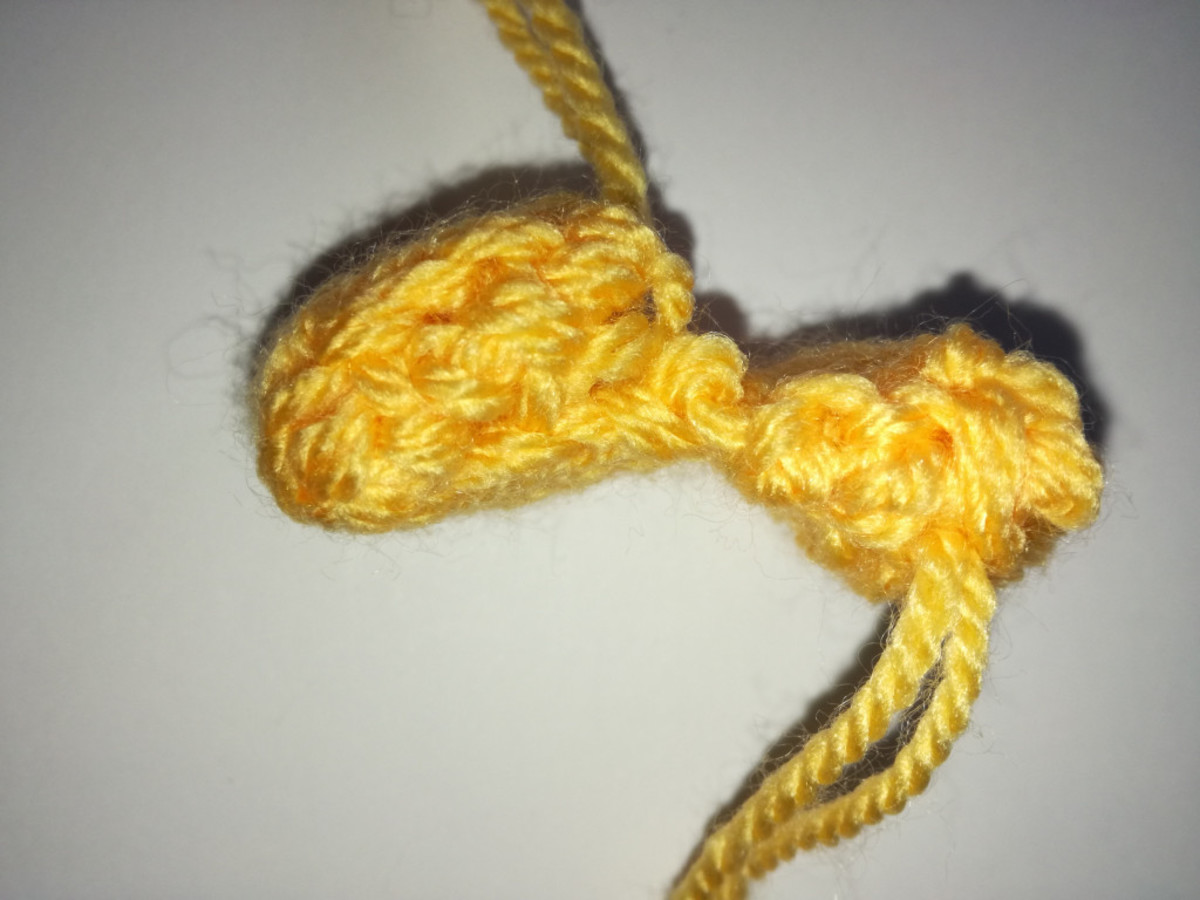 Photo 3. An example of one of the shoes, but in yellow yarn. Folded toe (left), rolled heel (right).