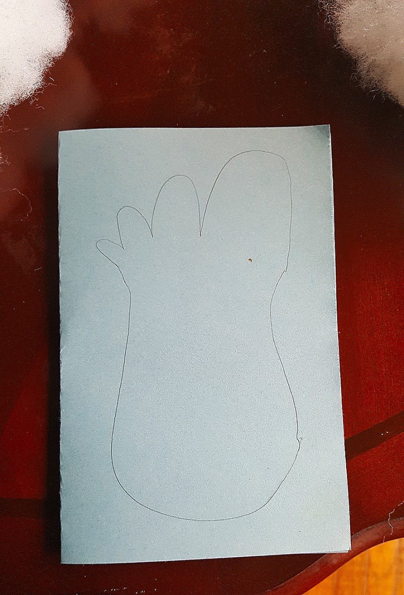 Fold a blue sheet of construction paper in half, hamburger style, and draw a foot shape.