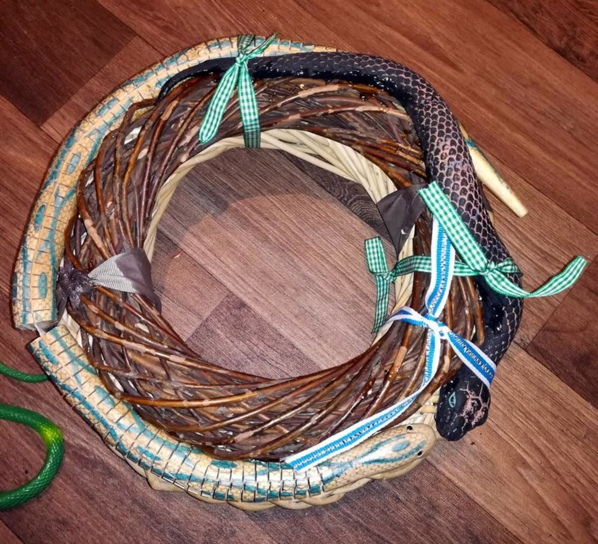 Attach the rubber snakes to the Halloween wreath.